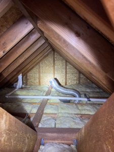 A bathroom exhaust fan duct terminating directly into an attic space, a major moisture defect discussed in our home inspection attic tips.