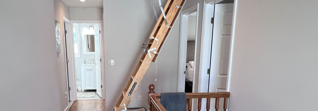 A professional home inspector using a pull-down ladder to provide home inspection attic tips in a North Jersey residence.